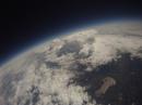 A view looking down on a cloud formation with the balloon near the peak of its flight.