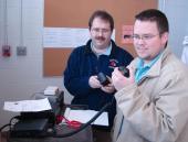 Two men talking on a radio inside.